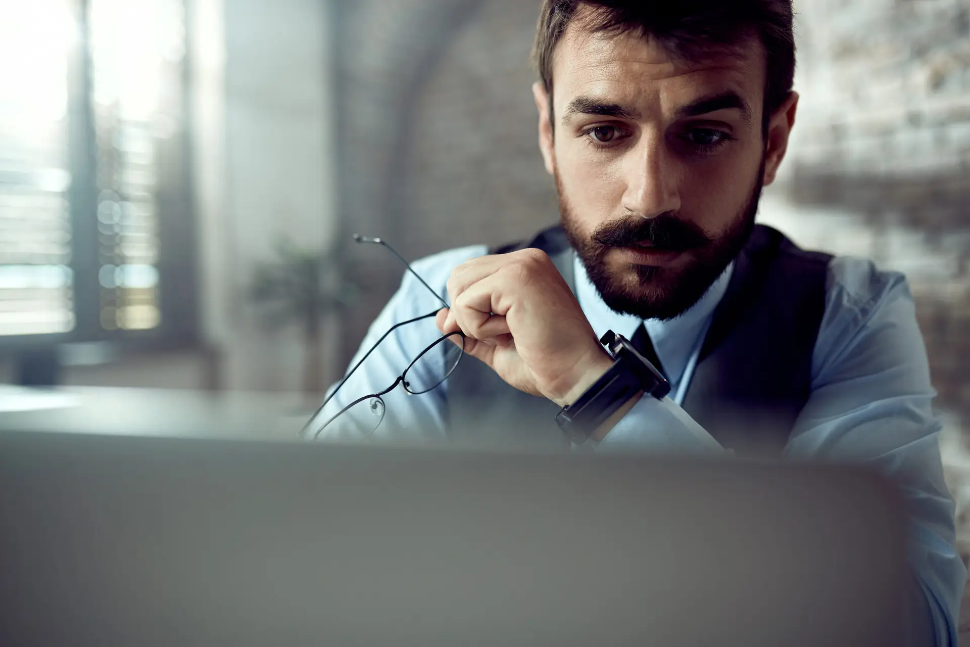 Frustrated office worker waiting on a slow internet connection with a loading icon on screen